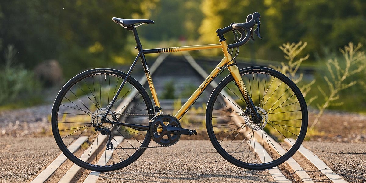 Golden Leopard All-City Cycles Zig Zag 105 complete bike side view on railroad crossing