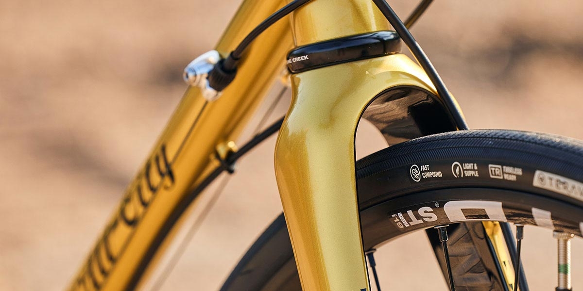 Close-up of All-City Zig Zag Golden Leopard bike, focus on fork crown and downtube