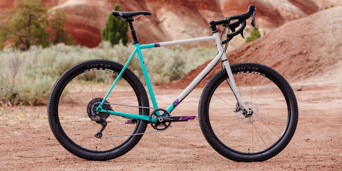 All-City Gorilla Monsoon GRX complete bike in Aqua Seafoam color, side view against outdoor background