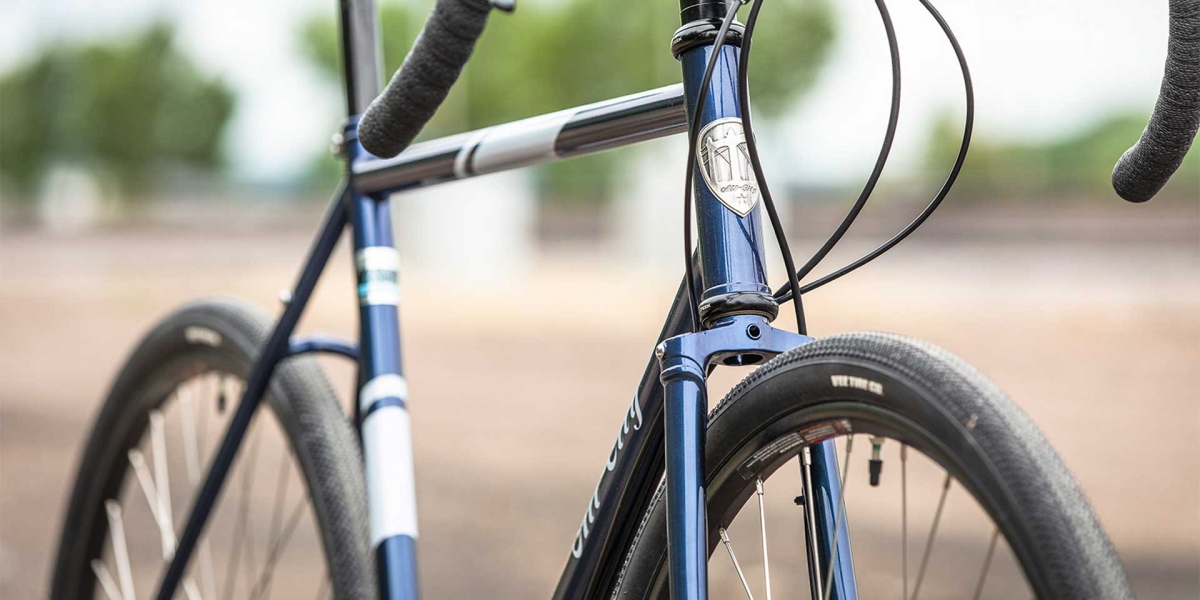 All-City blue Spacehorse bike, close up frame view with an outdoor background