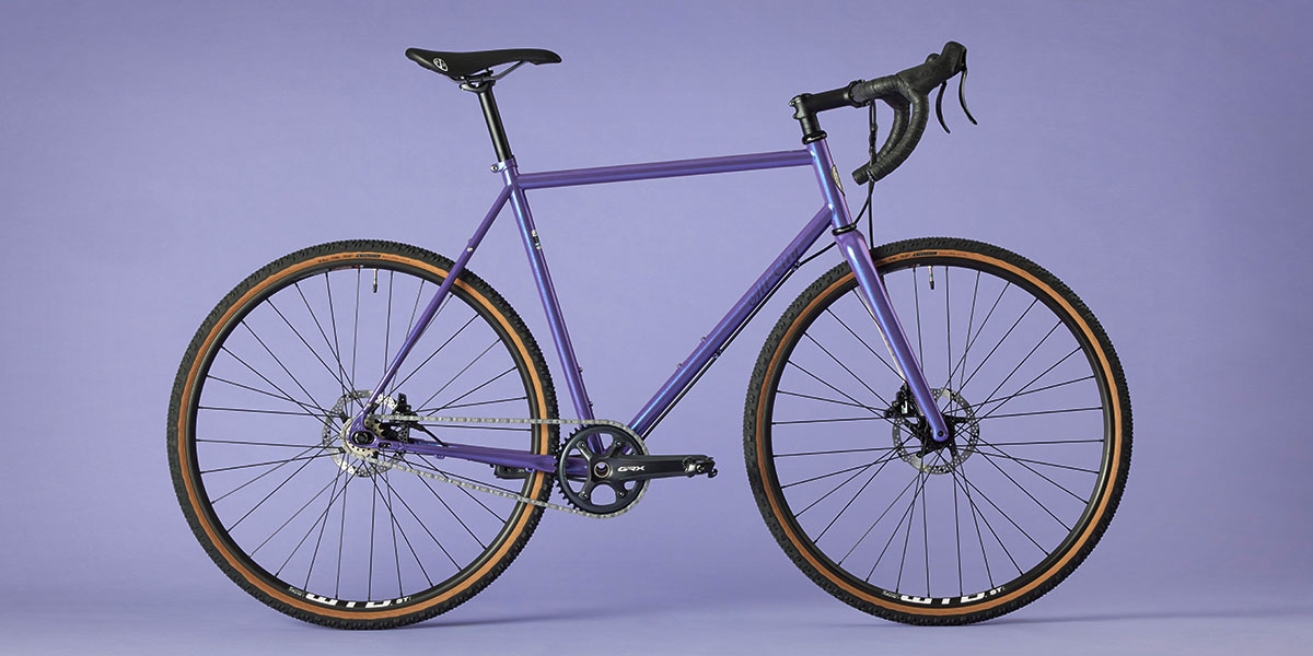 All-City Cycles Super Professional Single Speed Drop Bar bike in Hollywood Violet side view on purple background