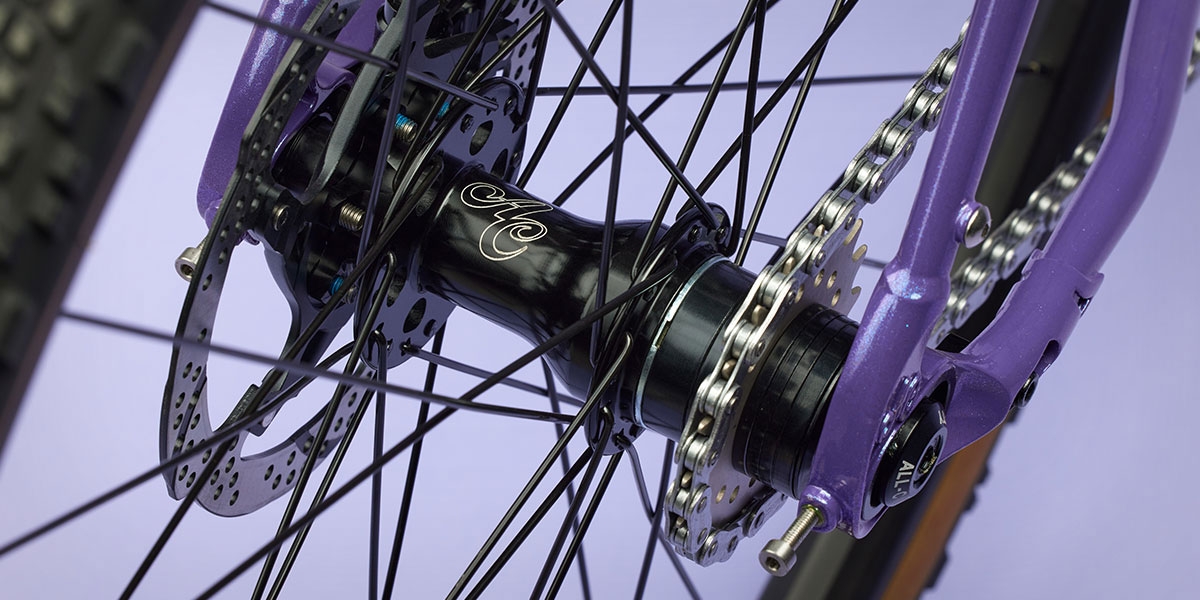 All-City Cycles Super Professional Single Speed Drop Bar bike in Hollywood Violet close-up of rear hub and single speed cog/chain