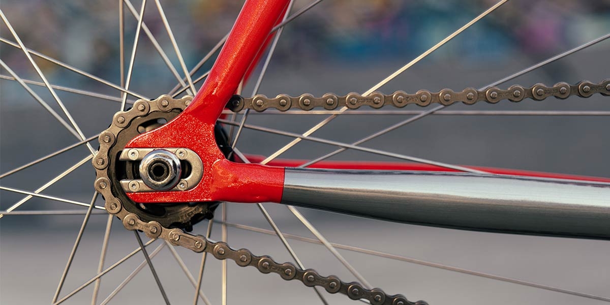 Red All-City Thunderdome bike rear dropouts, cog, chain and polished drive-side chainstay
