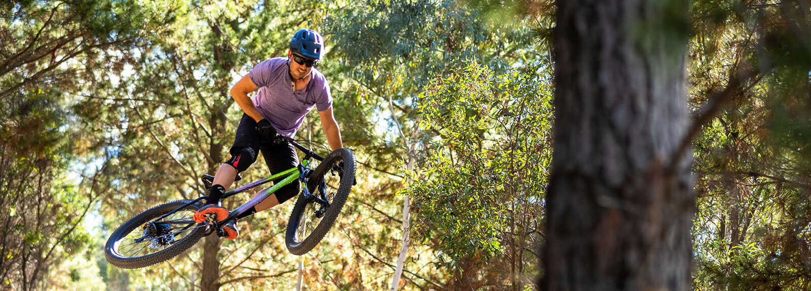 Perosn rides Electric Queen bike through green woods