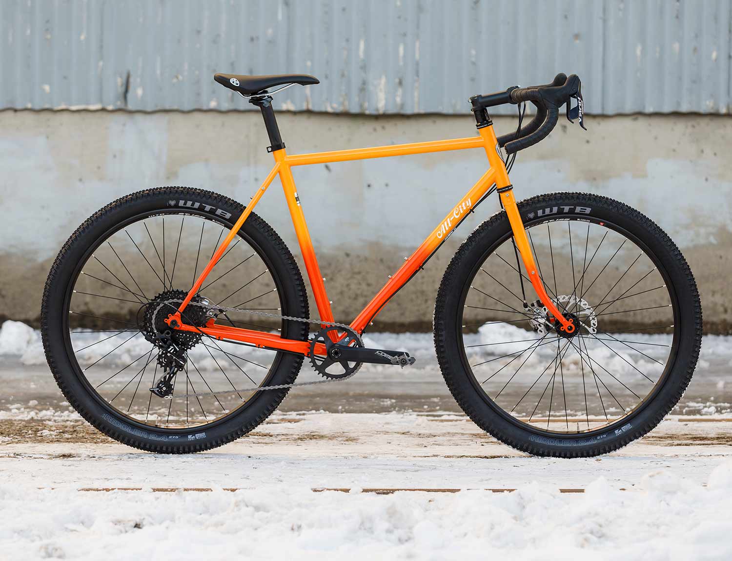 Gorilla Monsoon orange fade bike against concrete wall