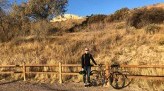 Lauren Rothering smiles next to bike with southwest desert background