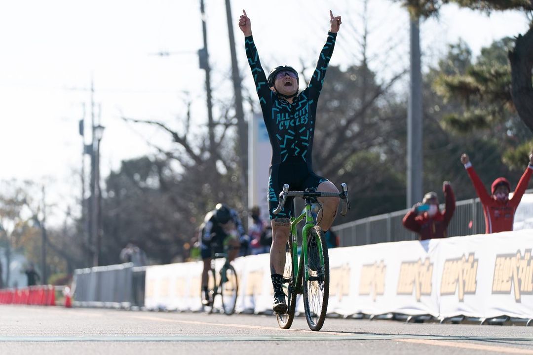 Koshi racing his cyclocross bike crossing finish line with arms overhead