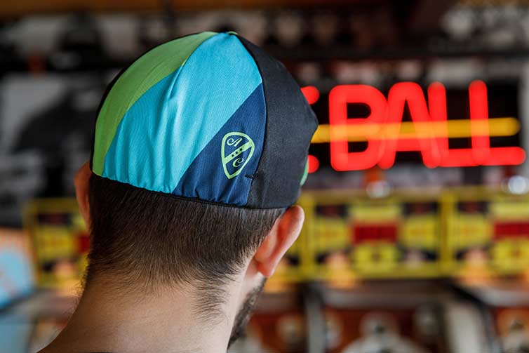 Person wears All-City cap in front of Up Down skee ball