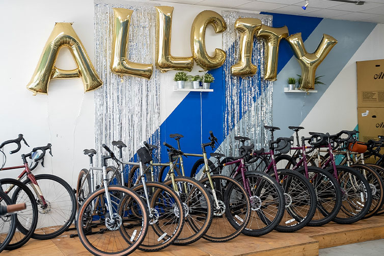 Inside City Bike Tampa, gold All-City balloon on wall in front on many All-City bike models on floor