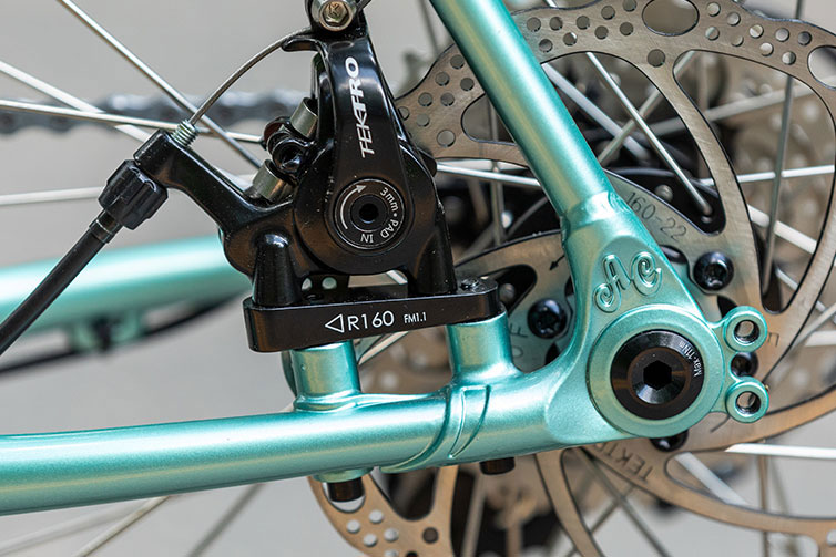 Close-up of rear disc caliper and dropout on Space Horse Tiagra bike, Royal Mint, showing AC logo above axle