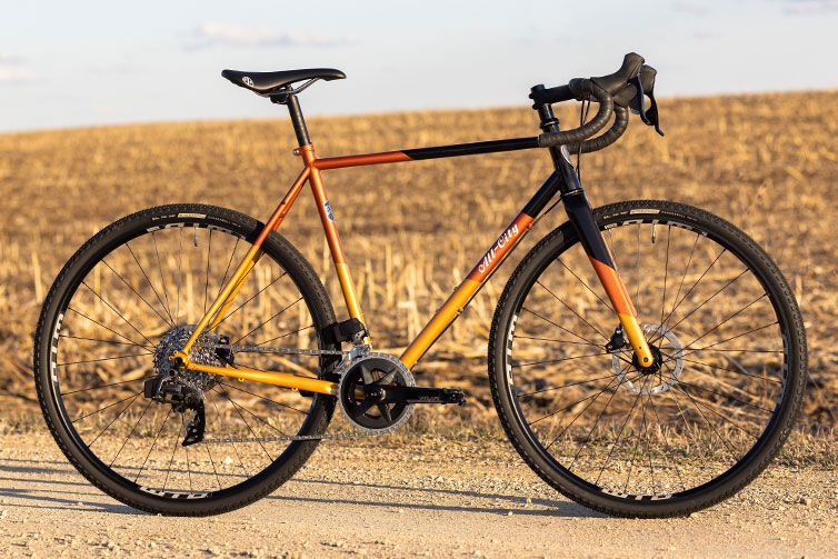 All-City Cosmic Stallion Rival AXS Wide complete bike, steel frame, side view on gravel road