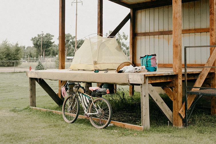 Kae-Lin tent/camp set-up on elevated building deck in town, loaded Gorilla Monsoon bike parked