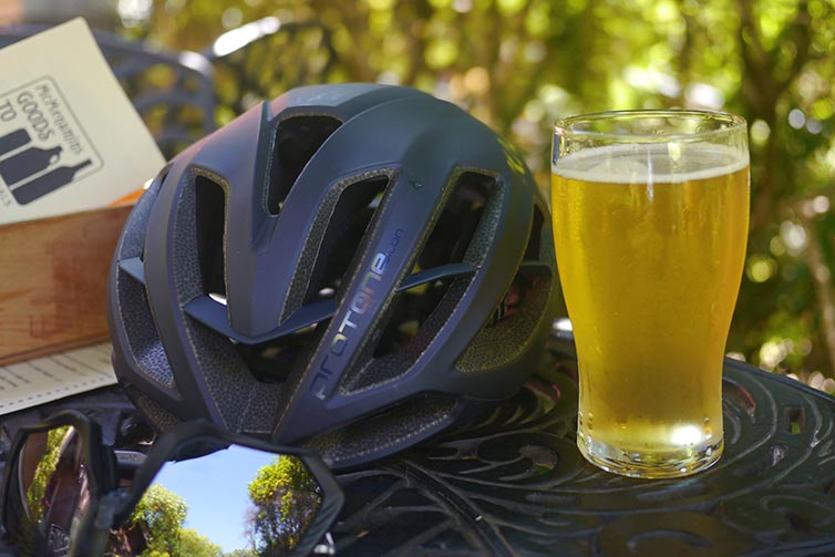 Table outside with glass of beer, helmet, and sunglasses