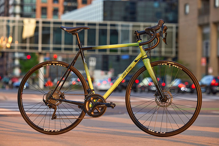 All-City Zig Zag 105 Honeydew Bling bike side view on a downtown sidewalk