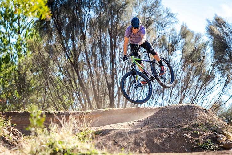 All-City Electric Queen Mountain Bike jumping out of a bermed corner