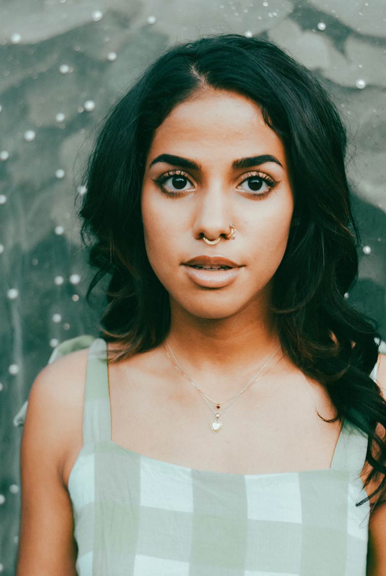 Emma Eudbanks headshot, wearing sundress, necklace and nose rings