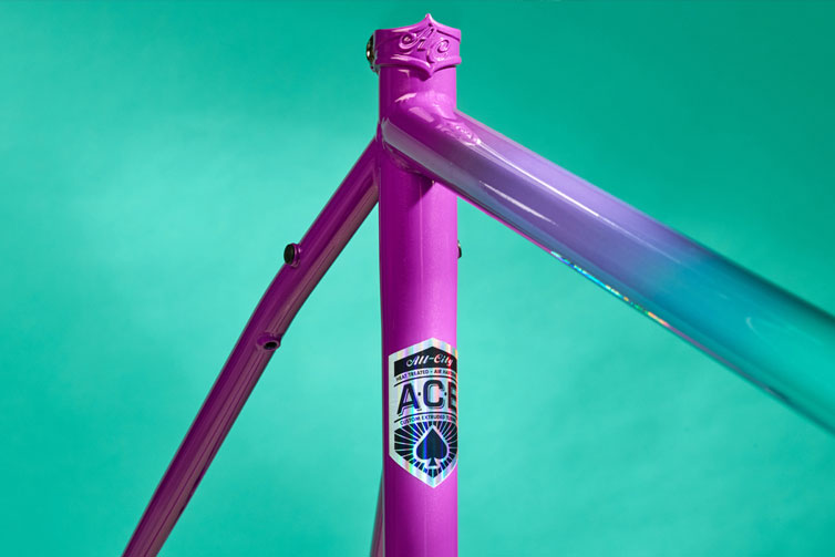 All-City Cosmic Stallion frameset in Mermaid Fade color detail of top tube and braze-on seat post collar on teal background