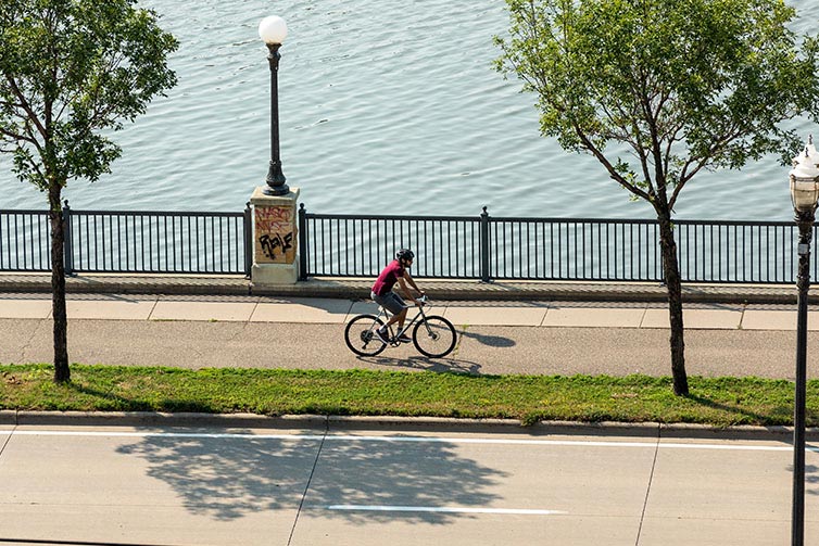 View from above of person riding Space Horse on bike path next to river