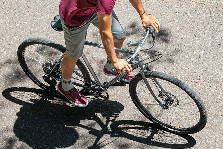 Person riding Space Horse bike coasting out of saddle, focus on bike