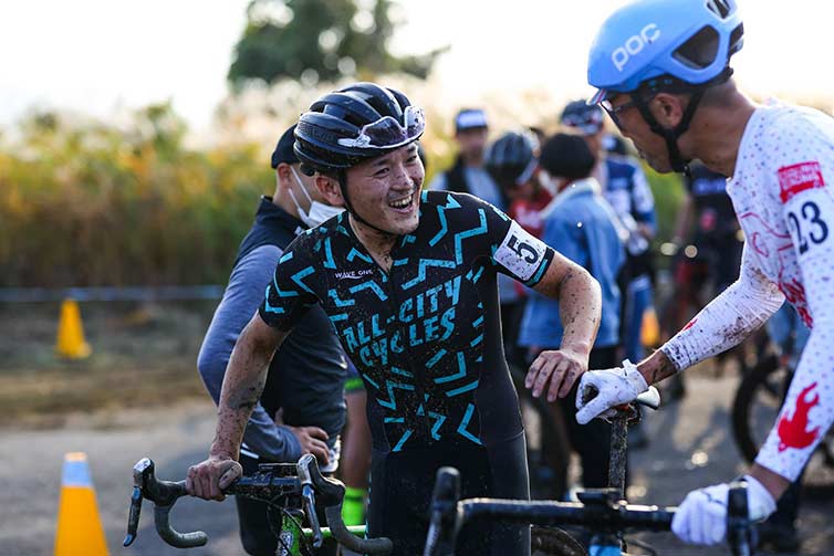 Koshi post cyclocross race, with bike, talking with fellow bike racer