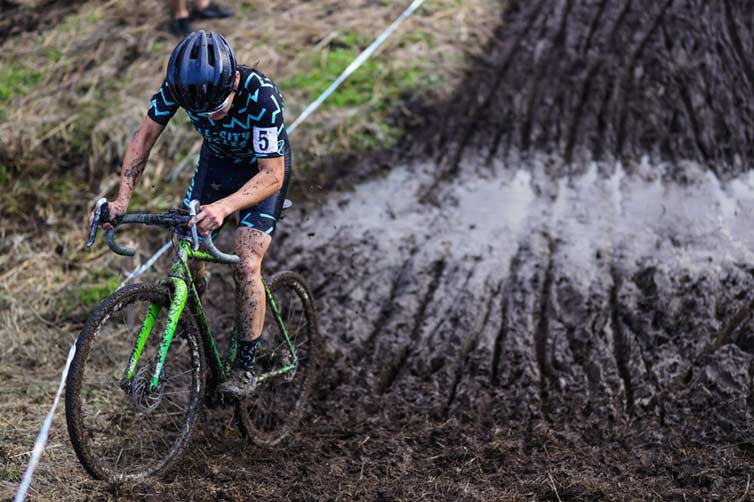 Koshi riding through mud pit during cyclocross race