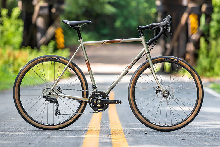 All-City gold Spacehorse bike, full bike view with an outdoor background