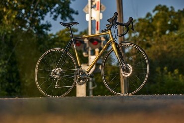All-City Zig Zag 105 Golden Leopard bike side view on railroad crossing