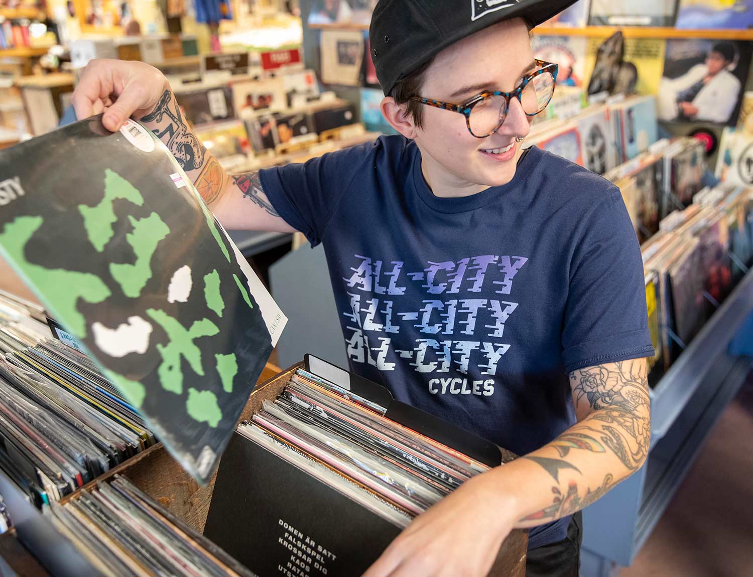 Person wearing blue All-City flow motion t-shirt in store