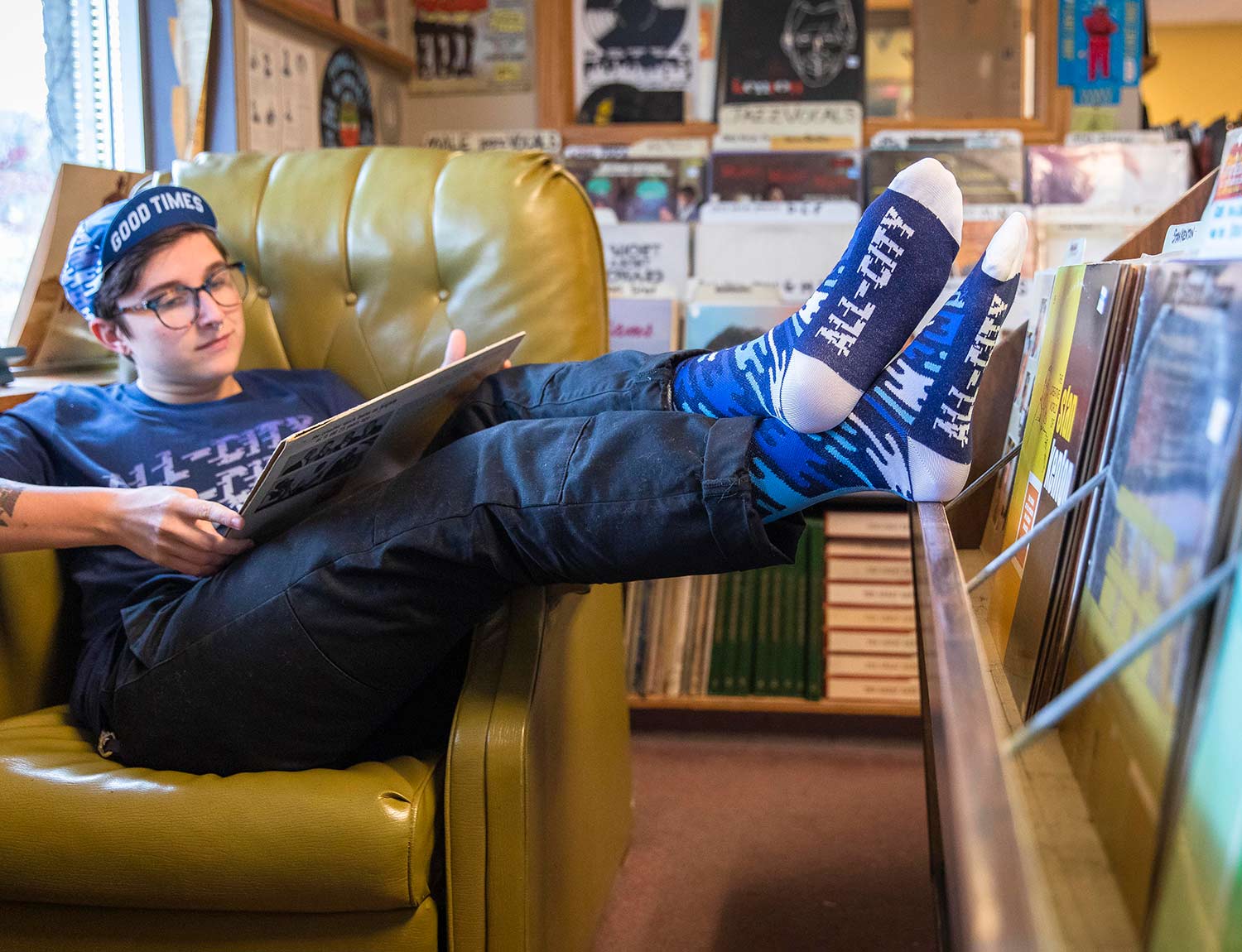Person wearing All-City Flow Motion blue wool socks with feet up 