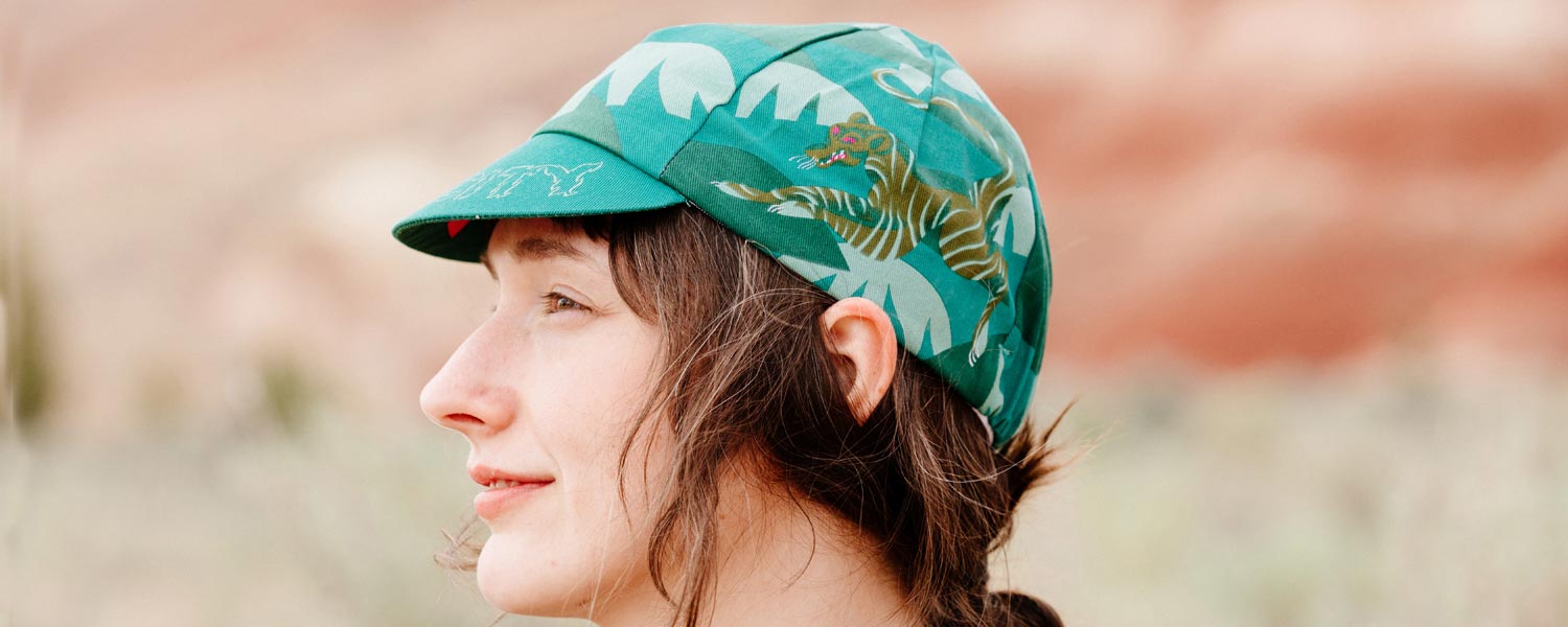 Person wearing All-City Claw Cycling Cap outside showing illustrated design, side view