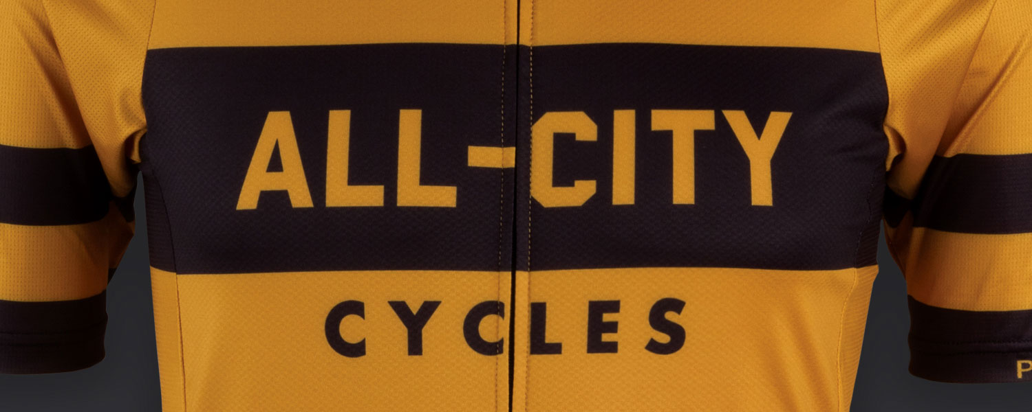 Close-up of Logowear Jersey design, All-City Cycles block font logo on mustard color jersey material