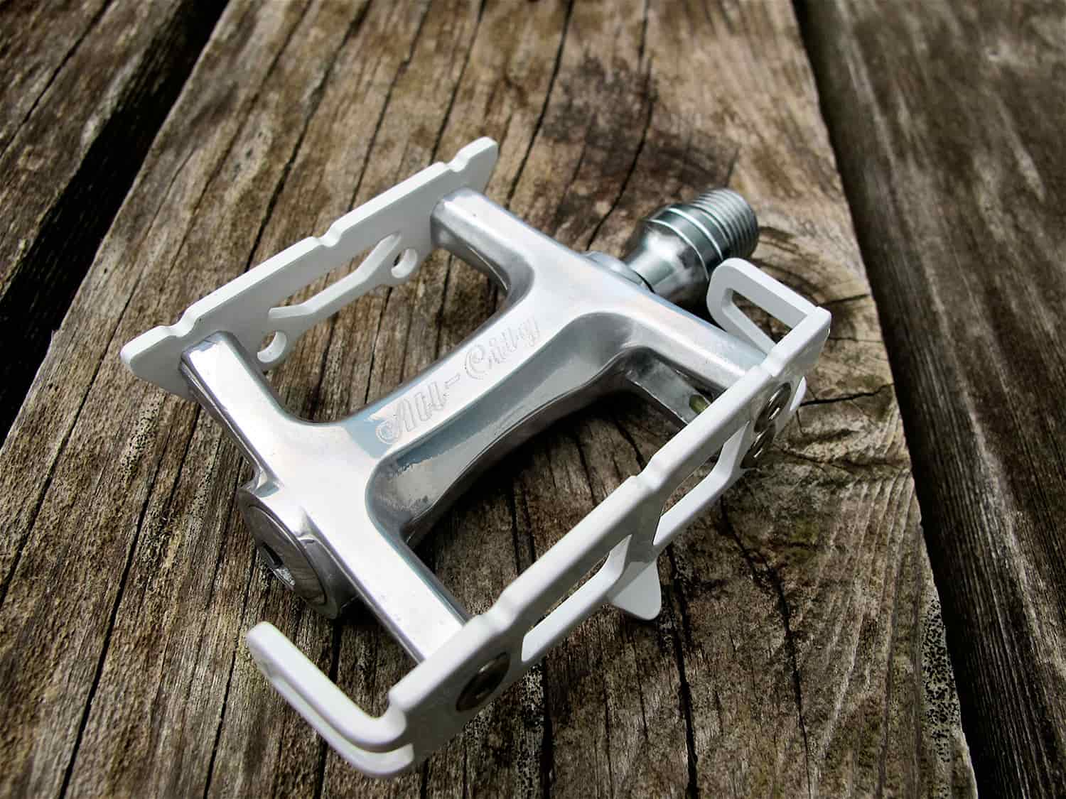 Polished silver All-City Cecil Pro pedal on wood background