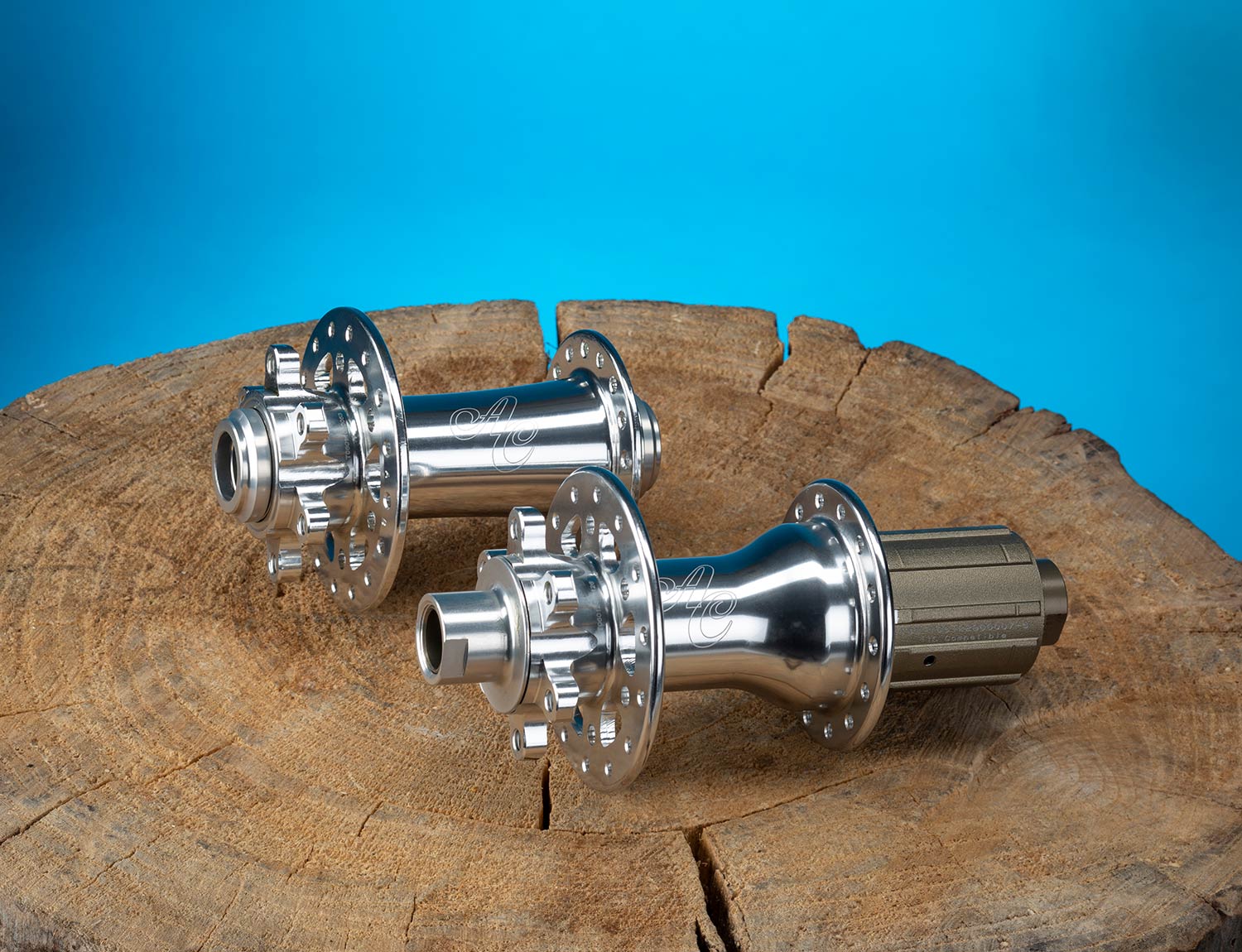 Two polished silver All-City Go-Devil Freehub Bodies on brown table with blue background 