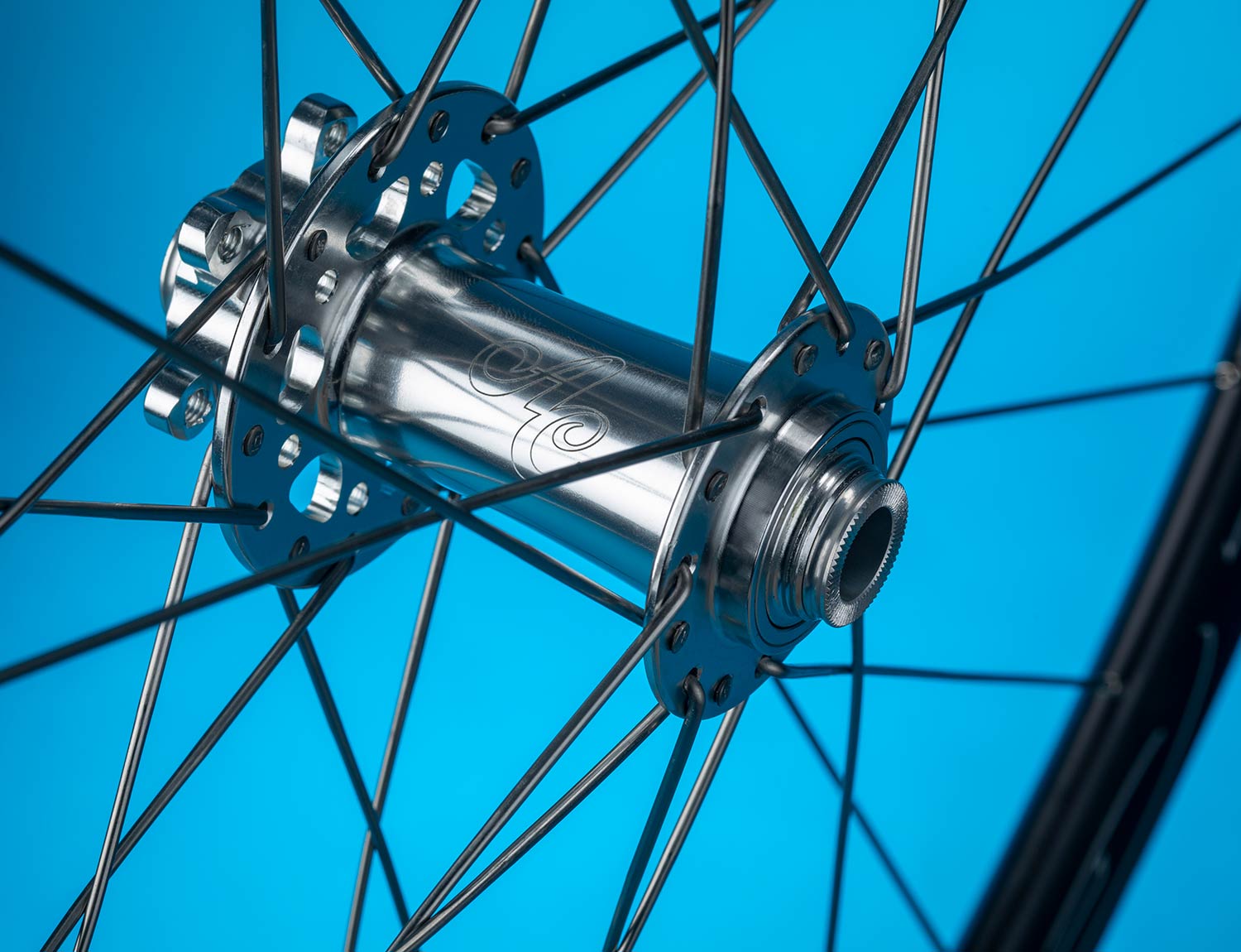 all city go devil front disc hub shown on spoke against blue background