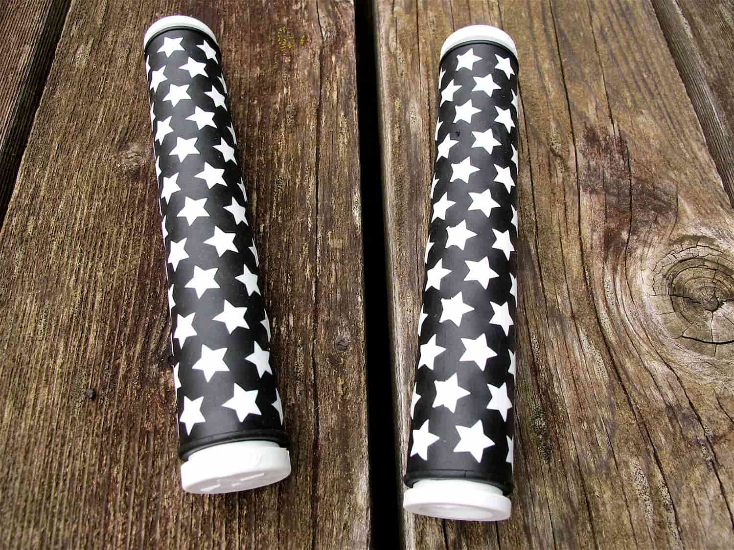 Two black and white All-City cycles Star Track grips on wood background 