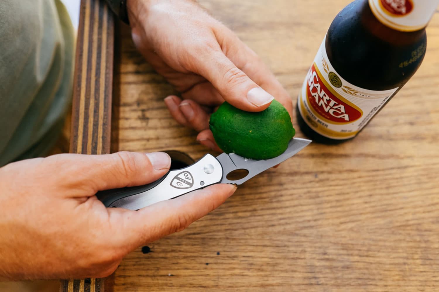 Person uses silver All-City knife to cut lime