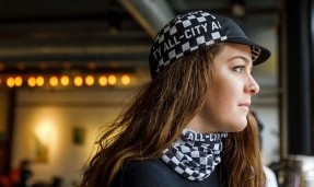 Person looking out window wearing black and white All-City Cycles Tu Tone Neck Gaiter