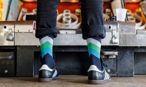 Back view of a person wearing blue, green, white, and black interstellar wool socks 