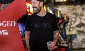 Person wears black All-City Cycles Travel Wool Shirt in arcade