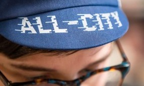 Close up of person wearing blue All-City flow motion cycling cap