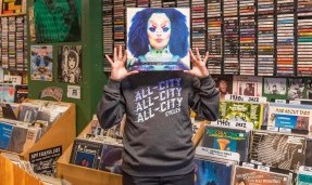 Person wears Grey All-City Flow Motion crewneck sweatshirt as they hold a record over their face