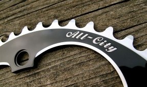 Black All-City 612 Track Ring close up on wood background