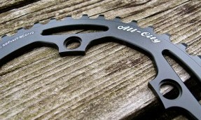 Black All-City cycles Cross Chainring on wood background close-up view 