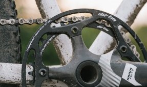 Black All-City cycles Cross Chainring on wood background side view on grey bike 