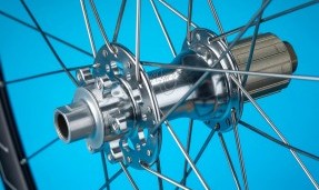 Polished Silver All-City Cycles Go-Devil Rear Disc Hub on wheel with blue background