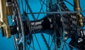 Black All-City Cycles Go-Devil Rear Disc Hub on wheel with blue background