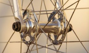 Polished silver and black All-City New Sheriff SL Rear hub on yellow wheel