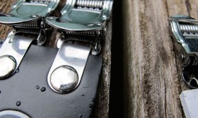 Polished silver All-City Cycle Standard Doubles toe strap close up on wood background