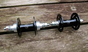Two black and silver All-City Standard Track Front hubs on wood background, top view