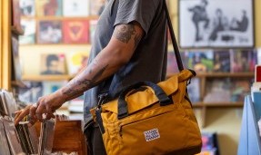 Person with Beat Box Bag using shoulder strap in record store
